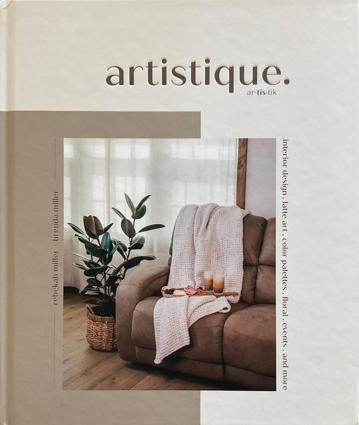Book cover of 'artistique' with a living room scene featuring a brown sofa, plant, and decor items.