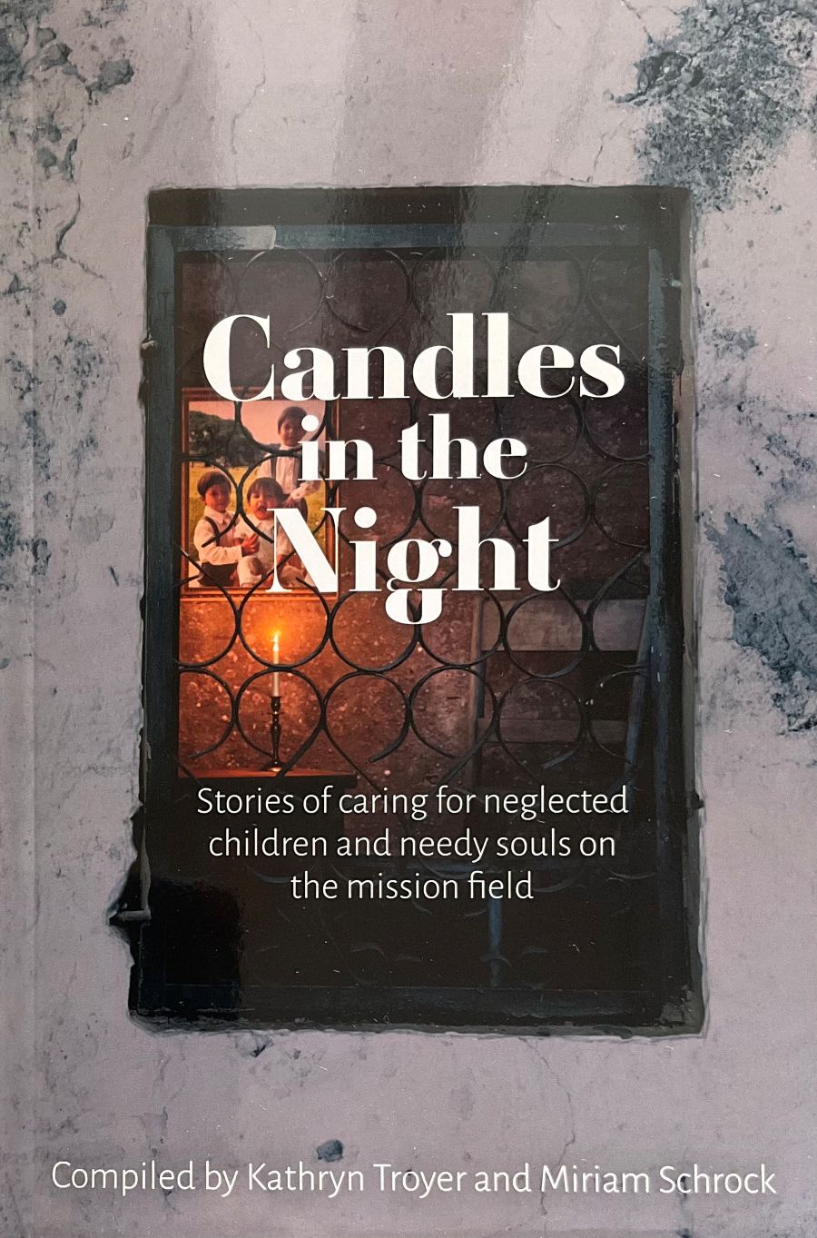 Book titled 'Candles in the Night' on a textured surface