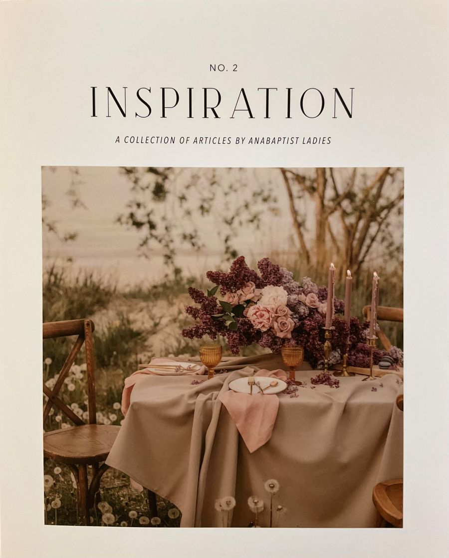 Table setting with flowers and candles in a natural setting, featuring the word 'Inspiration'.