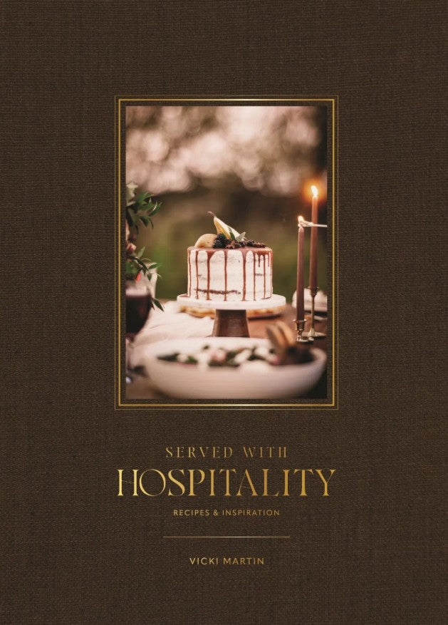 Book cover of 'Served with Hospitality' featuring a cake on a table.