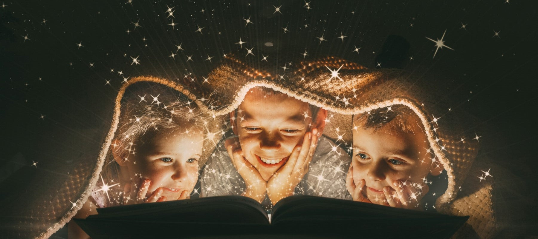 Picture of children reading under a blanket.