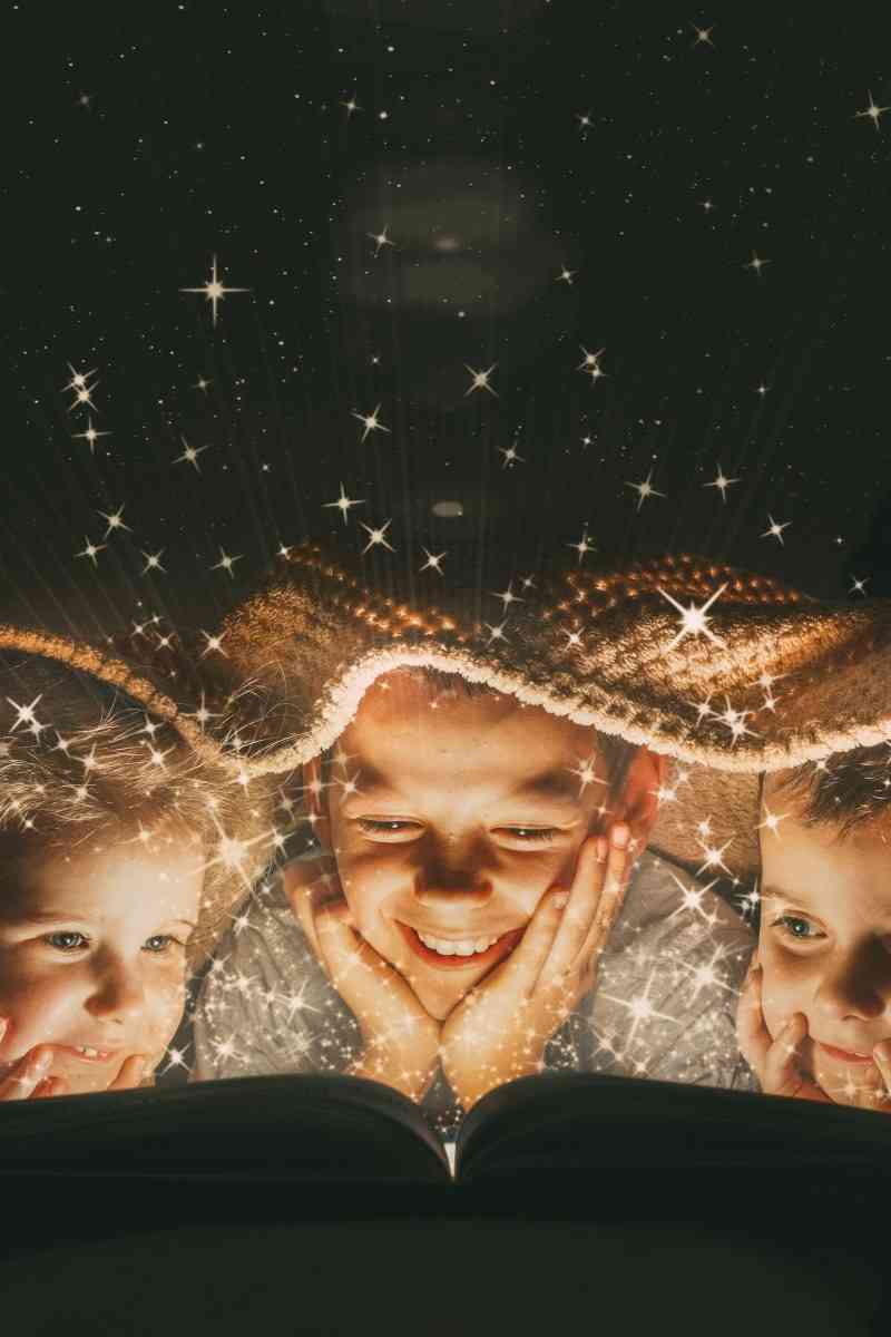 Picture of children reading under a blanket.