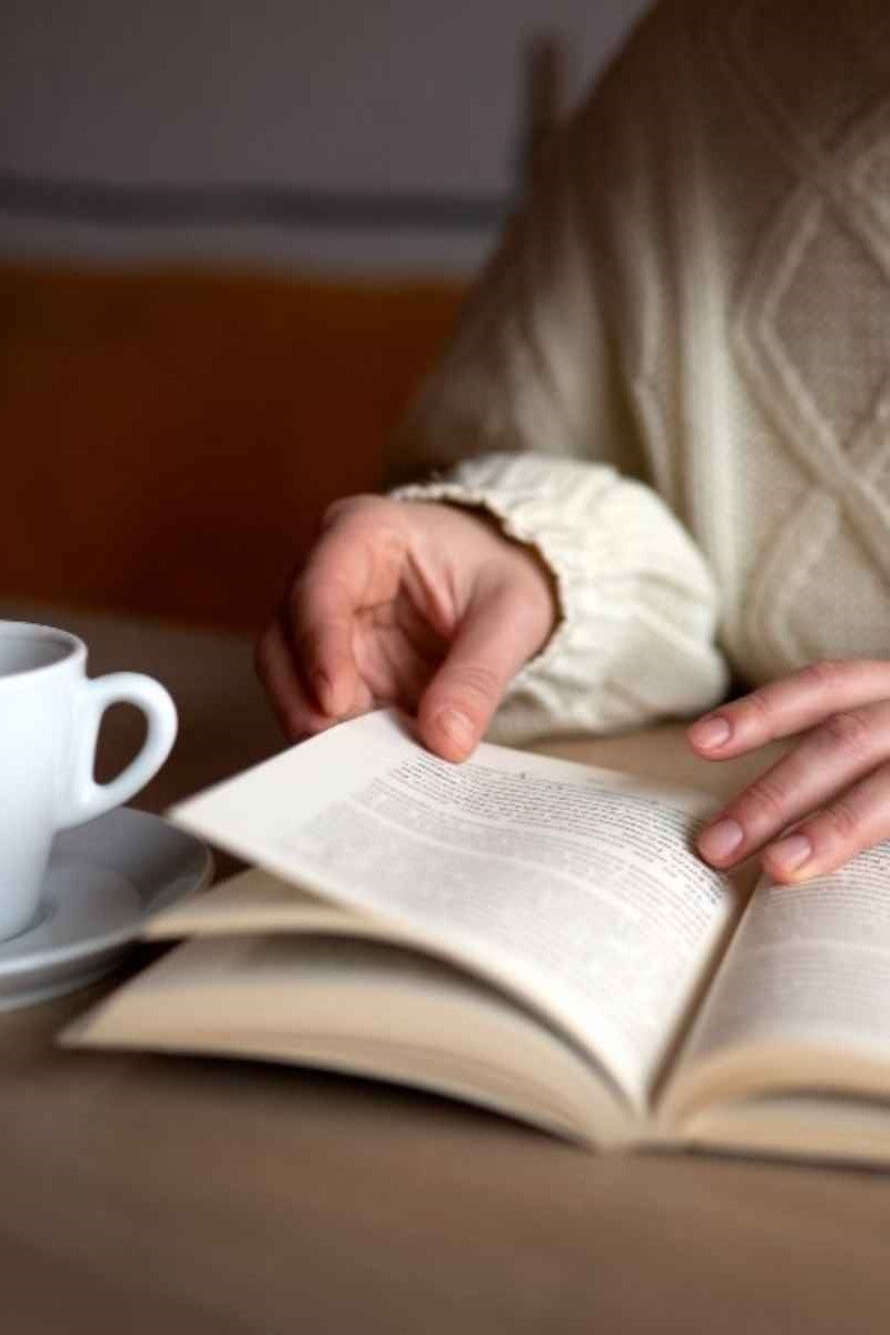 Picture of reading a book while having coffee.