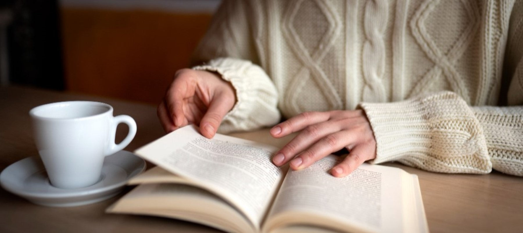 Picture of reading a book while having coffee.